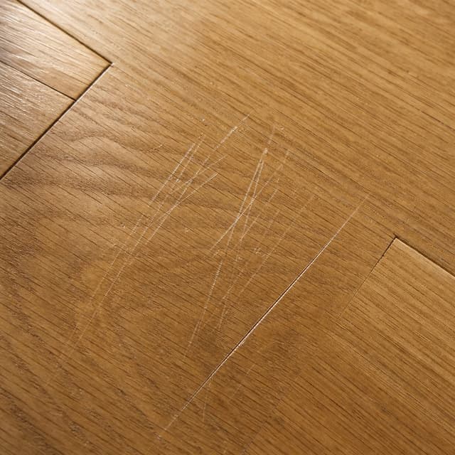 Parkettoberfläche mit sichtbaren Kratzern als Beispiel für Hundekratzer